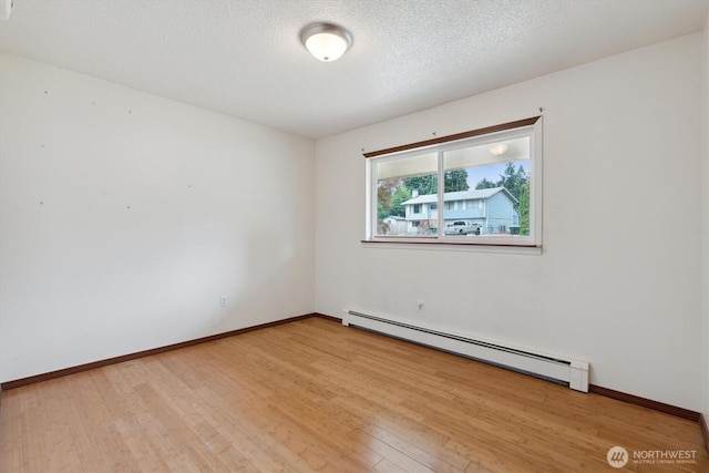 2598 25th Loop SE, Lacey, WA 98503 - empty room with a baseboard heating unit, light wood-style flooring, and a textured ceiling