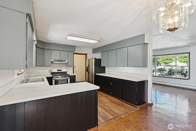 2598 25th Loop SE, Lacey, WA 98503 - kitchen featuring stainless steel gas range oven, under cabinet range hood, a baseboard radiator, fridge with ice dispenser, and light countertops