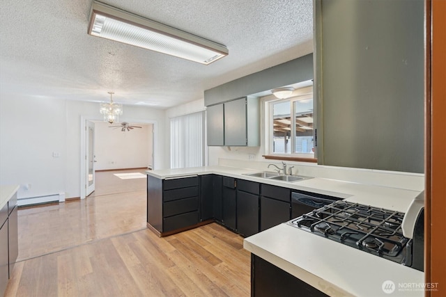 2598 25th Loop SE, Lacey, WA 98503 - kitchen with a baseboard heating unit, a textured ceiling, light countertops, a chandelier, and a peninsula
