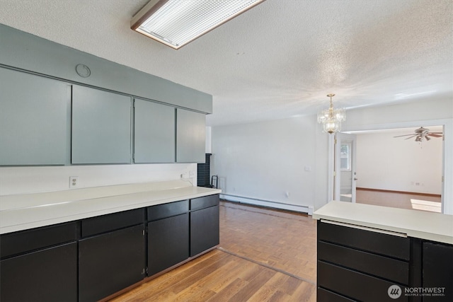 2598 25th Loop SE, Lacey, WA 98503 - kitchen featuring a baseboard heating unit, light countertops, a textured ceiling, a chandelier, and pendant lighting