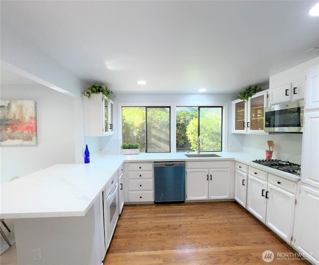 1711 159th Pl NE Unit 29, Bellevue, WA 98008 - kitchen featuring stainless steel appliances, a peninsula, glass insert cabinets, white cabinetry, and recessed lighting