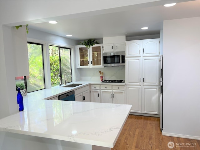 1711 159th Pl NE Unit 29, Bellevue, WA 98008 - kitchen with stainless steel microwave, a peninsula, dishwasher, gas stovetop, and light stone counters