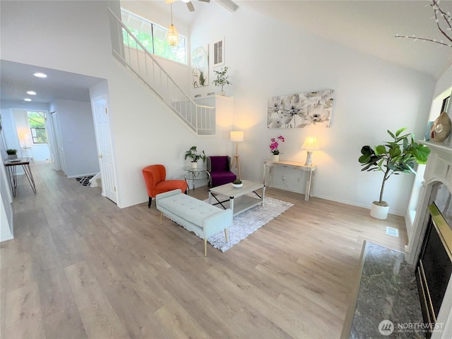 1711 159th Pl NE Unit 29, Bellevue, WA 98008 - living area featuring a fireplace, high vaulted ceiling, wood finished floors, and stairway