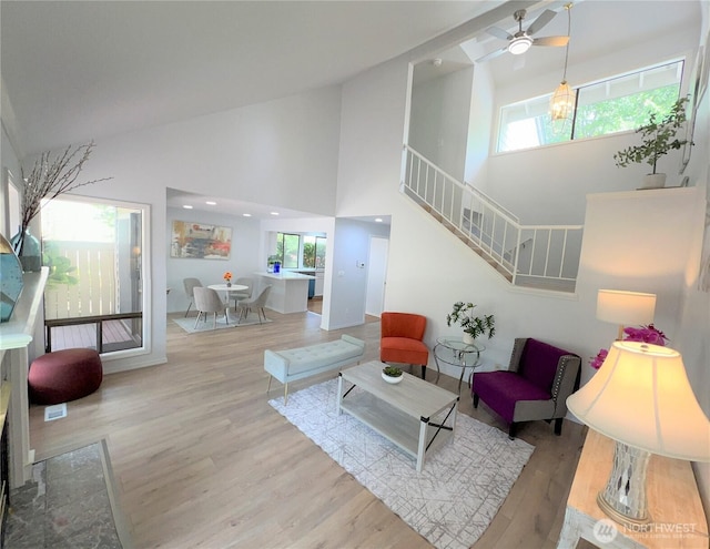 1711 159th Pl NE Unit 29, Bellevue, WA 98008 - living area featuring healthy amount of natural light, high vaulted ceiling, wood finished floors, ceiling fan, and stairs