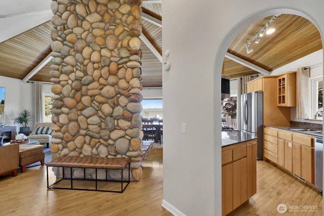 6926 Holeman Ave, Blaine, WA 98230 - interior space featuring track lighting, arched walkways, wooden ceiling, light wood-style floors, and freestanding refrigerator