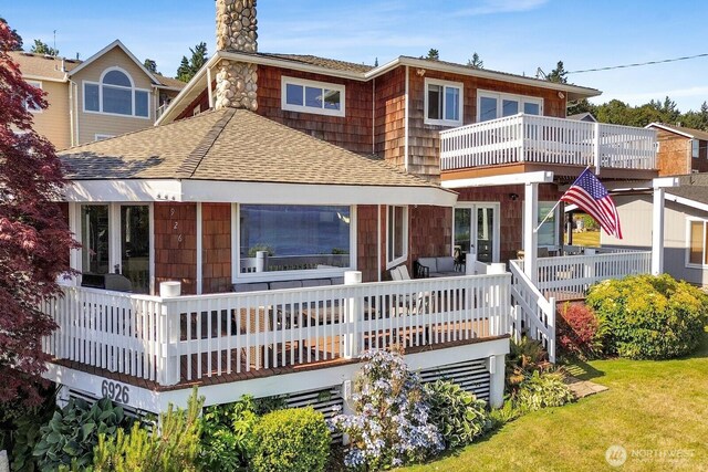 6926 Holeman Ave, Blaine, WA 98230 - back of house with a shingled roof, a balcony, a chimney, and a yard