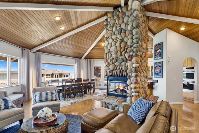 6926 Holeman Ave, Blaine, WA 98230 - living room with a wooden ceiling with exposed beams, wood finished floors, a fireplace, recessed lighting, and arched walkways