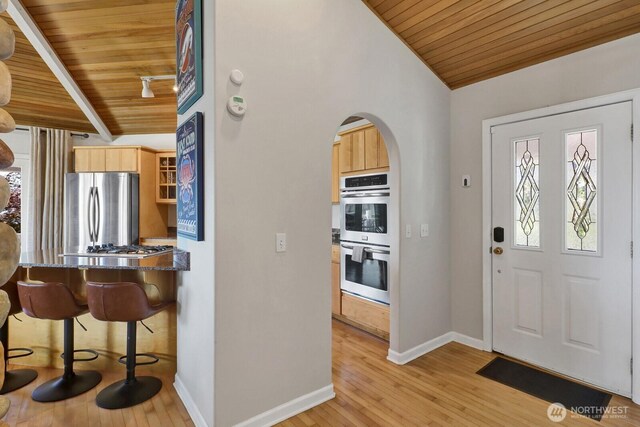 6926 Holeman Ave, Blaine, WA 98230 - entrance foyer with wooden ceiling, arched walkways, light wood-style floors, and lofted ceiling