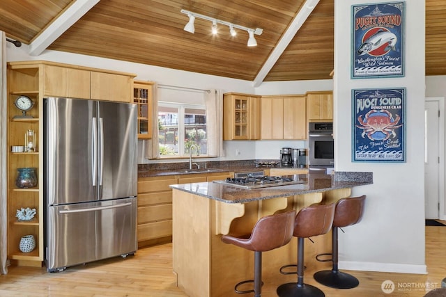 6926 Holeman Ave, Blaine, WA 98230 - kitchen with stainless steel appliances, wood ceiling, track lighting, light brown cabinetry, and dark stone countertops