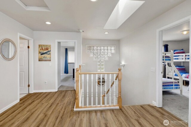 6926 Holeman Ave, Blaine, WA 98230 - hall with an upstairs landing, wood finished floors, a skylight, and recessed lighting