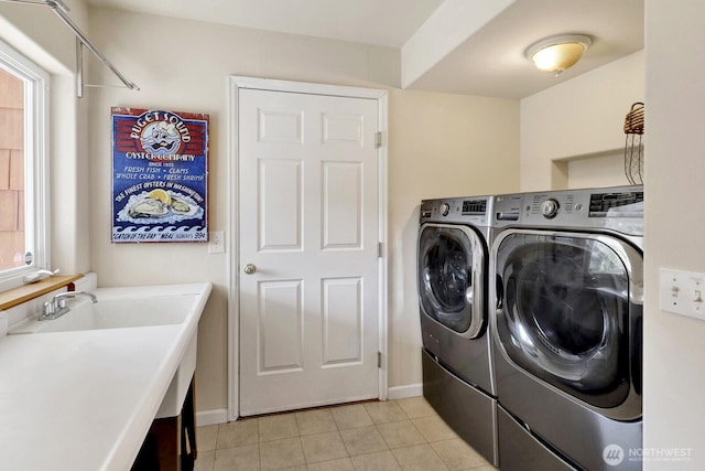 6926 Holeman Ave, Blaine, WA 98230 - laundry room featuring washer and dryer, light tile patterned flooring, and healthy amount of natural light