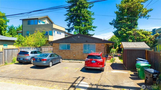 7343 35th SW, Seattle, WA 98126 - view of front facade featuring brick siding, uncovered parking, and a storage shed