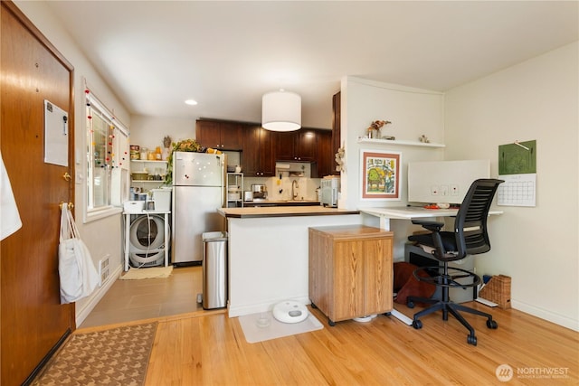 7343 35th SW, Seattle, WA 98126 - kitchen with freestanding refrigerator, light wood-style flooring, a peninsula, washer / dryer, and light countertops