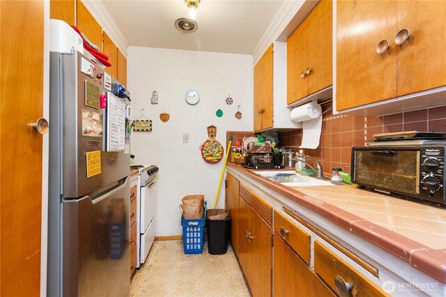 7343 35th SW, Seattle, WA 98126 - kitchen with freestanding refrigerator, tile countertops, white range oven, decorative backsplash, and brown cabinets