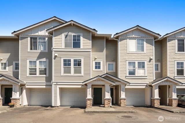 23218 62nd Ave S Unit 21-4, Kent, WA 98032 - townhome / multi-family property featuring an attached garage, board and batten siding, driveway, and stone siding