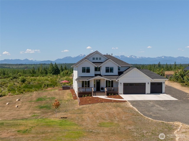381 E Benson Ridge Rd, Grapeview, WA 98546 - modern farmhouse featuring covered porch, driveway, a garage, and a mountain view