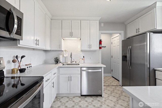 213 S 58th St, Tacoma, WA 98408 - kitchen featuring stainless steel appliances, decorative backsplash, white cabinetry, light floors, and light stone counters