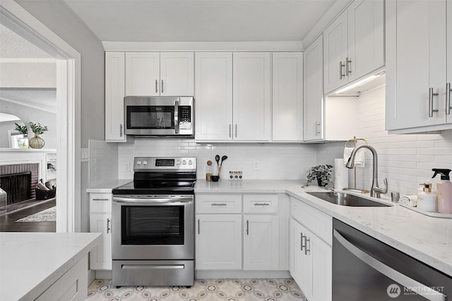 213 S 58th St, Tacoma, WA 98408 - kitchen with stainless steel appliances, light stone countertops, and white cabinetry
