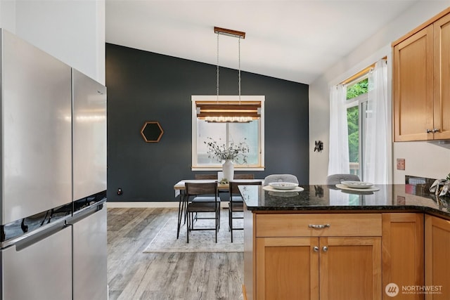 49 Cascade Ln, Bellingham, WA 98229 - kitchen with lofted ceiling, freestanding refrigerator, light wood-style floors, a peninsula, and dark stone counters