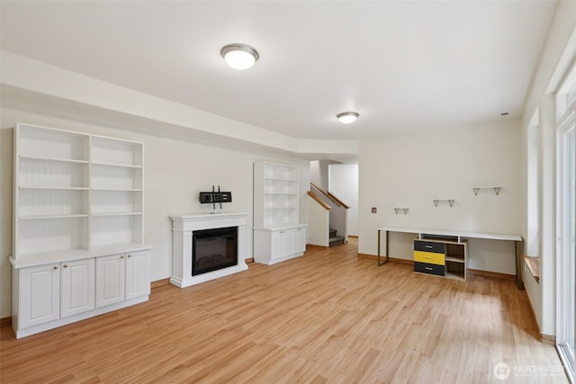 49 Cascade Ln, Bellingham, WA 98229 - unfurnished living room featuring light wood-type flooring, stairway, and a glass covered fireplace