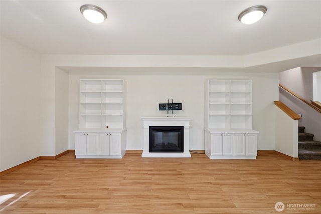 49 Cascade Ln, Bellingham, WA 98229 - unfurnished living room featuring light wood finished floors, stairway, built in features, and a glass covered fireplace