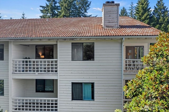 700 N 160th St Unit A316, Shoreline, WA 98133 - rear view of house with a balcony, a chimney, and a tiled roof