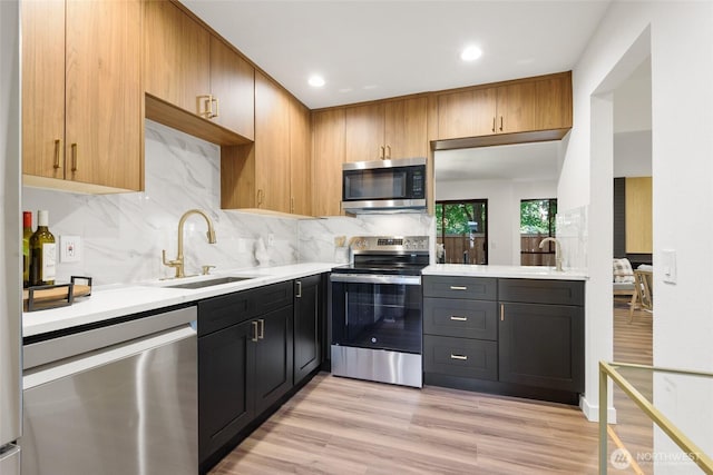 10305 NE 16th St Unit I6, Bellevue, WA 98004 - kitchen with appliances with stainless steel finishes, light countertops, decorative backsplash, light wood-style floors, and recessed lighting