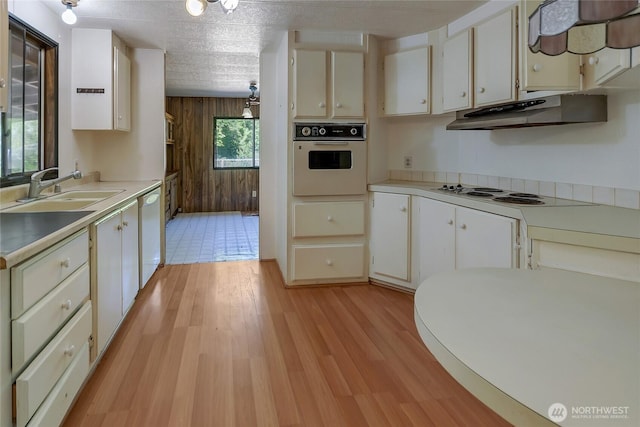 151 Dietz Dr, Quilcene, WA 98376 - kitchen featuring white appliances, under cabinet range hood, wooden walls, light wood-type flooring, and light countertops
