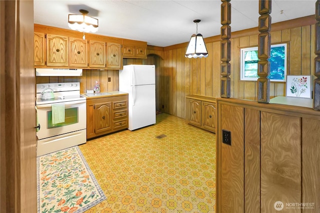31809 148th Way SE, Auburn, WA 98092 - kitchen featuring white appliances, under cabinet range hood, wood walls, brown cabinetry, and light countertops
