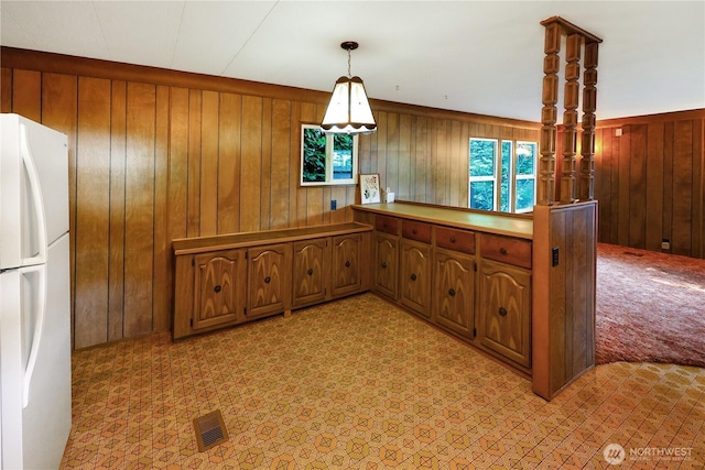 31809 148th Way SE, Auburn, WA 98092 - kitchen with freestanding refrigerator, light colored carpet, wood walls, brown cabinets, and hanging light fixtures