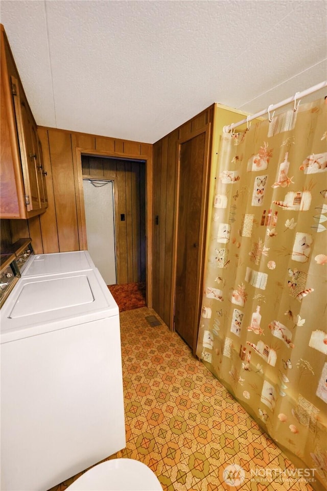 31809 148th Way SE, Auburn, WA 98092 - washroom with washing machine and dryer, a textured ceiling, wood walls, and light floors