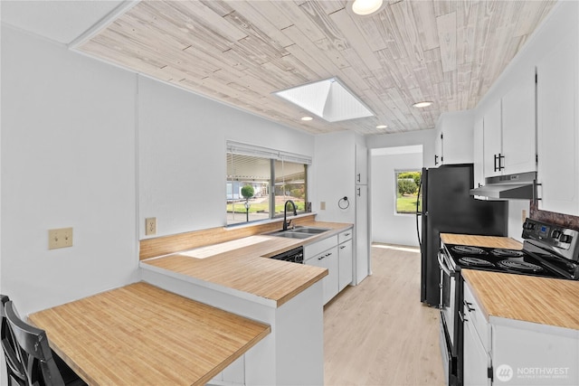 1402 22nd St NE Unit 39, Auburn, WA 98002 - kitchen with black range with electric cooktop, under cabinet range hood, a skylight, white cabinets, and light wood finished floors