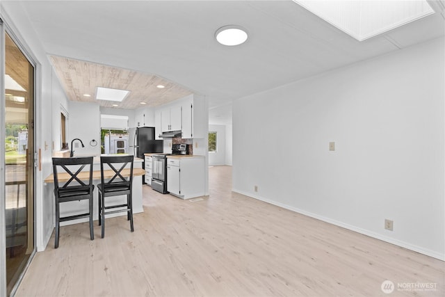 1402 22nd St NE Unit 39, Auburn, WA 98002 - kitchen featuring electric stove, a skylight, light wood-style floors, healthy amount of natural light, and recessed lighting
