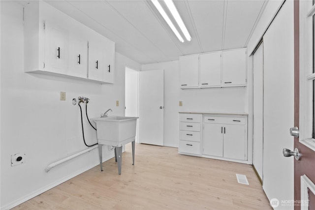 1402 22nd St NE Unit 39, Auburn, WA 98002 - laundry area featuring cabinet space, hookup for a washing machine, light wood-type flooring, and electric dryer hookup