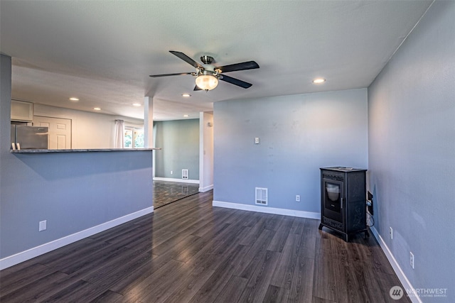 406 Brown Way SE, Orting, WA 98360 - unfurnished living room featuring a wood stove, ceiling fan, dark wood-style flooring, and recessed lighting