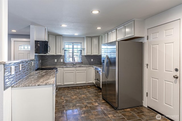 406 Brown Way SE, Orting, WA 98360 - kitchen featuring stainless steel appliances, light stone countertops, backsplash, recessed lighting, and white cabinets