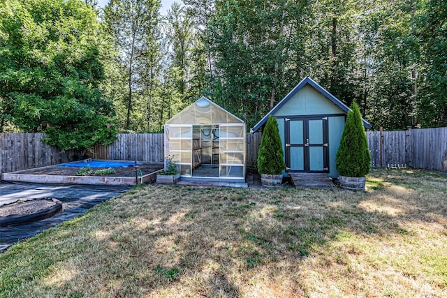 406 Brown Way SE, Orting, WA 98360 - view of greenhouse featuring a fenced backyard, a shed, and a vegetable garden