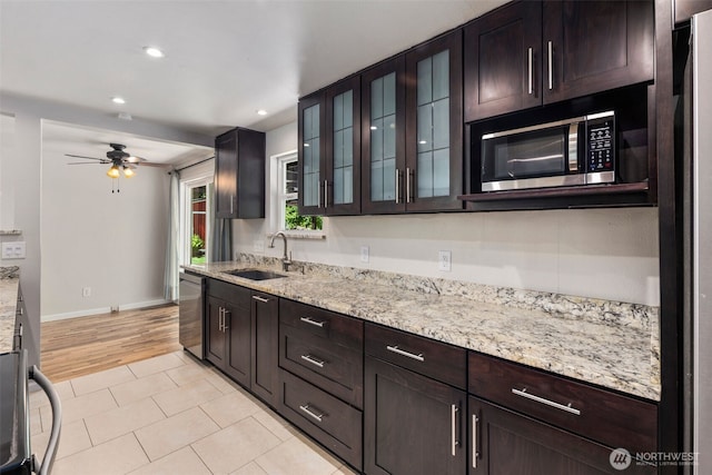 4006 147th Pl, Bellevue, WA 98006 - kitchen with stainless steel appliances, light tile patterned flooring, recessed lighting, light stone countertops, and glass insert cabinets