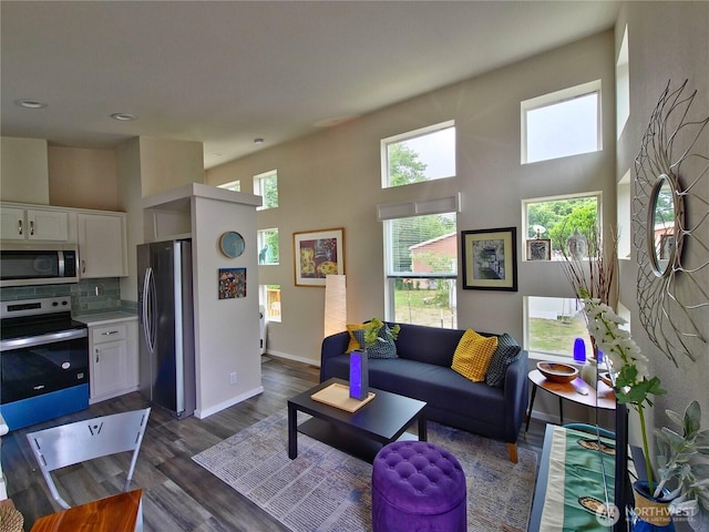 1303 30th Unit 3, Seaview, WA 98644 - living room featuring healthy amount of natural light, dark wood-type flooring, a towering ceiling, and recessed lighting