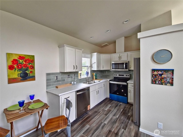 1303 30th Unit 2, Seaview, WA 98644 - kitchen with appliances with stainless steel finishes, light countertops, tasteful backsplash, white cabinetry, and lofted ceiling