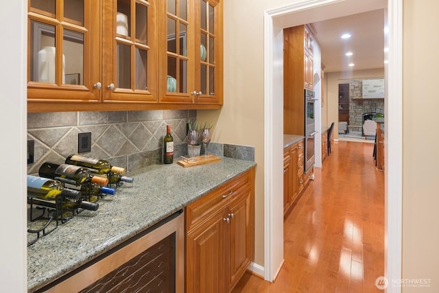 13695 NE 32nd Pl, Bellevue, WA 98005 - kitchen with light stone counters, light wood finished floors, tasteful backsplash, and brown cabinets