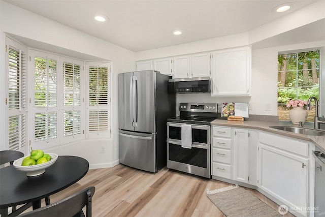 8527 134th Ct NE, Redmond, WA 98052 - kitchen with stainless steel appliances, white cabinets, light wood-style flooring, and recessed lighting