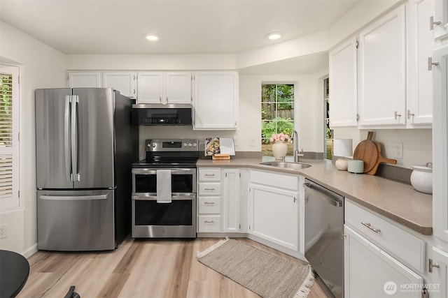 8527 134th Ct NE, Redmond, WA 98052 - kitchen with appliances with stainless steel finishes, white cabinetry, light countertops, recessed lighting, and light wood finished floors