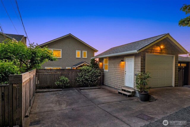 7117 Beach Dr SW, Seattle, WA 98136 - property exterior at dusk with entry steps, a garage, an outdoor structure, a patio, and a shingled roof