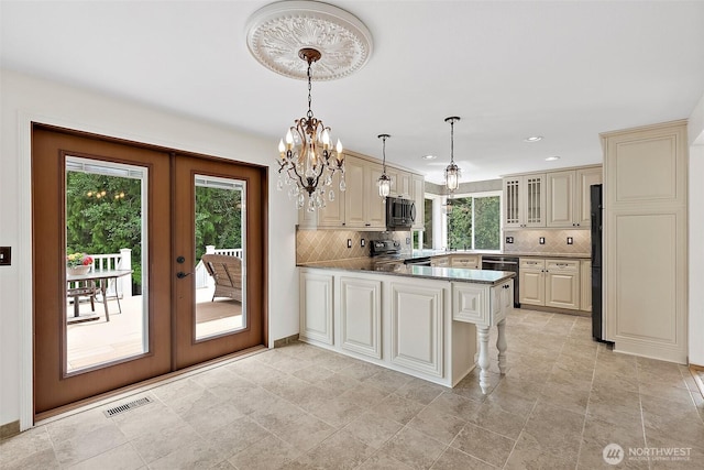 14013 116th Ave E, Puyallup, WA 98374 - kitchen with appliances with stainless steel finishes, french doors, a peninsula, backsplash, and cream cabinetry