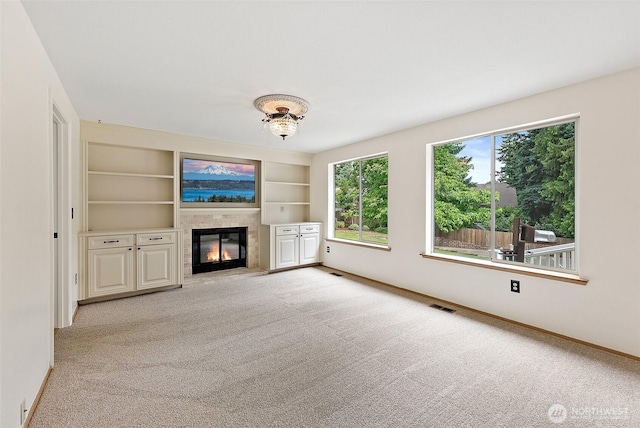 14013 116th Ave E, Puyallup, WA 98374 - unfurnished living room with a glass covered fireplace, light carpet, and built in shelves