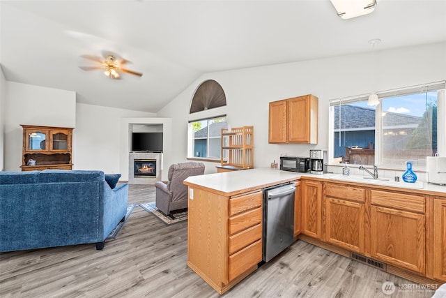 1346 Chatham Dr SE, Olympia, WA 98513 - kitchen featuring dishwasher, a peninsula, lofted ceiling, open floor plan, and a tiled fireplace