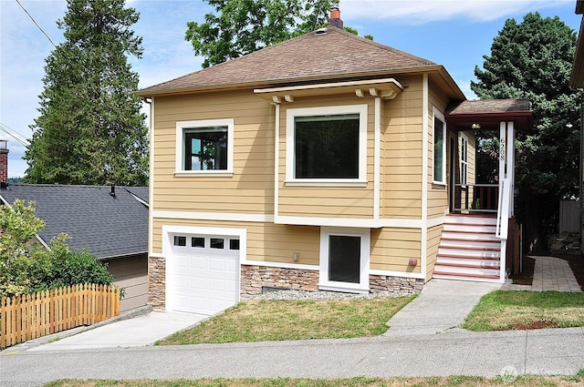 6208 Fremont Ave N, Seattle, WA 98103 - view of front of house with an attached garage, stone siding, a chimney, and a shingled roof