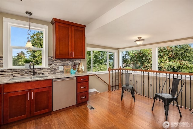 6208 Fremont Ave N, Seattle, WA 98103 - kitchen featuring dishwasher, decorative backsplash, light wood-type flooring, pendant lighting, and light stone countertops