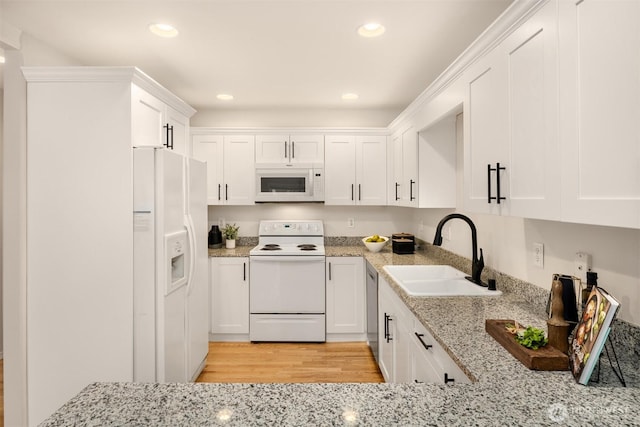 17515 110th Ln SE Unit 27, Renton, WA 98055 - kitchen with white appliances, white cabinetry, recessed lighting, light stone countertops, and light wood-style floors
